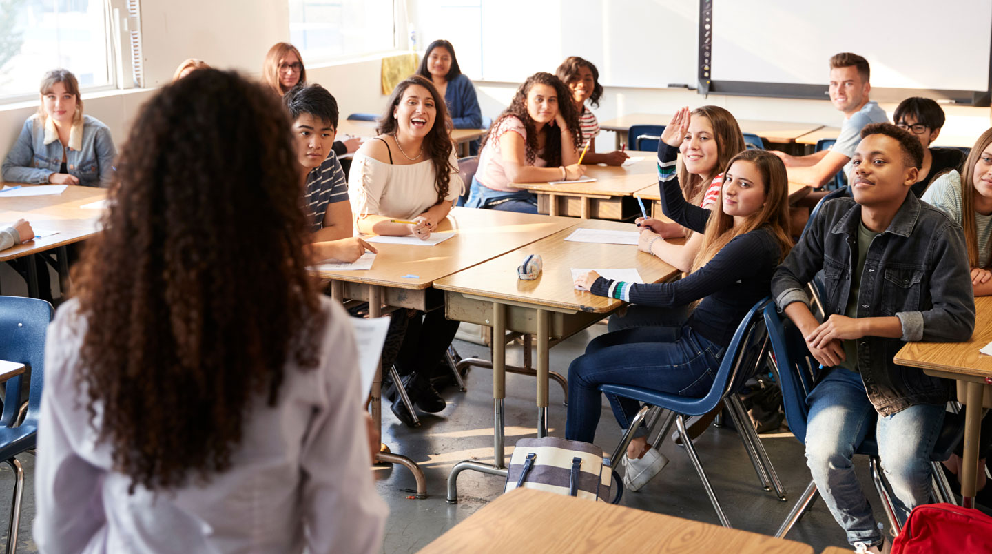 Salle de classe moderne avec mobilier ergonomique, un étudiant travaille sur un ordinateur.
